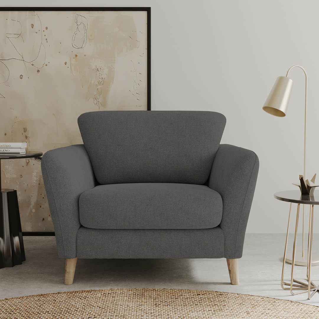 Fauteuil confortable gris foncé avec une assise large et des pieds en bois, parfait pour un intérieur moderne.