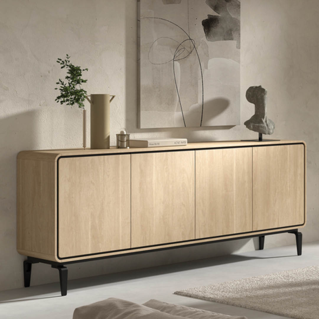 Licht houten dressoir met vier deuren en een afgeronde afwerking. Het zwarte onderstel zorgt voor een luchtige en moderne uitstraling.