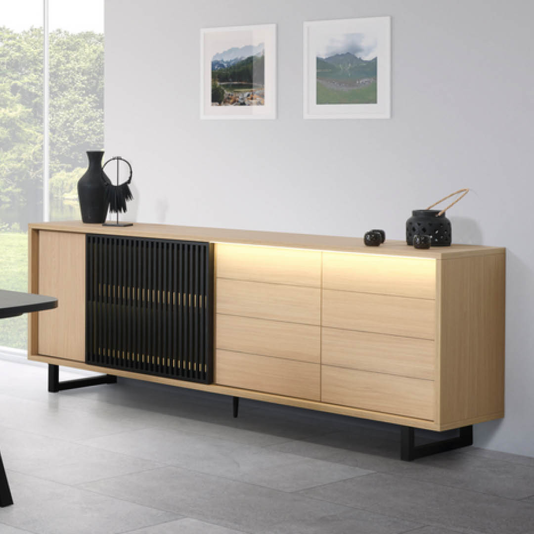 Buffet moderne avec une finition en bois clair, deux portes et une porte coulissante avec des lames noires. Ses pieds fins en métal lui confèrent une allure élégante.