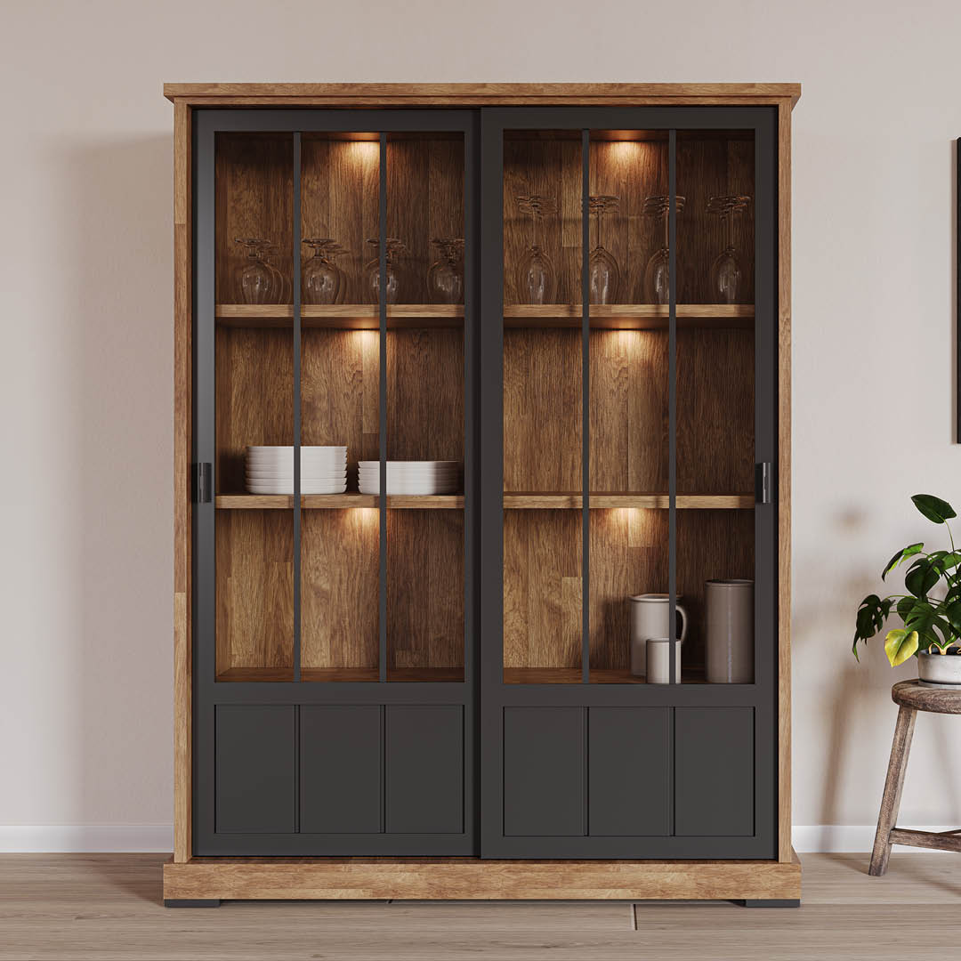 Stijlvolle vitrinekast in een rustieke houtkleur met zwarte accenten. Uitgerust met 2 schuifdeuren, 3 glazen legplanken en een ruime opbergruimte onderin.
